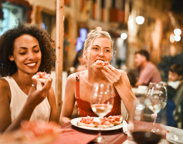 Woman enjoying Sparez Bowling entertainment with food and wine
