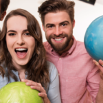 Two men and two women with colorful bowling balls ready for a great bowling party.