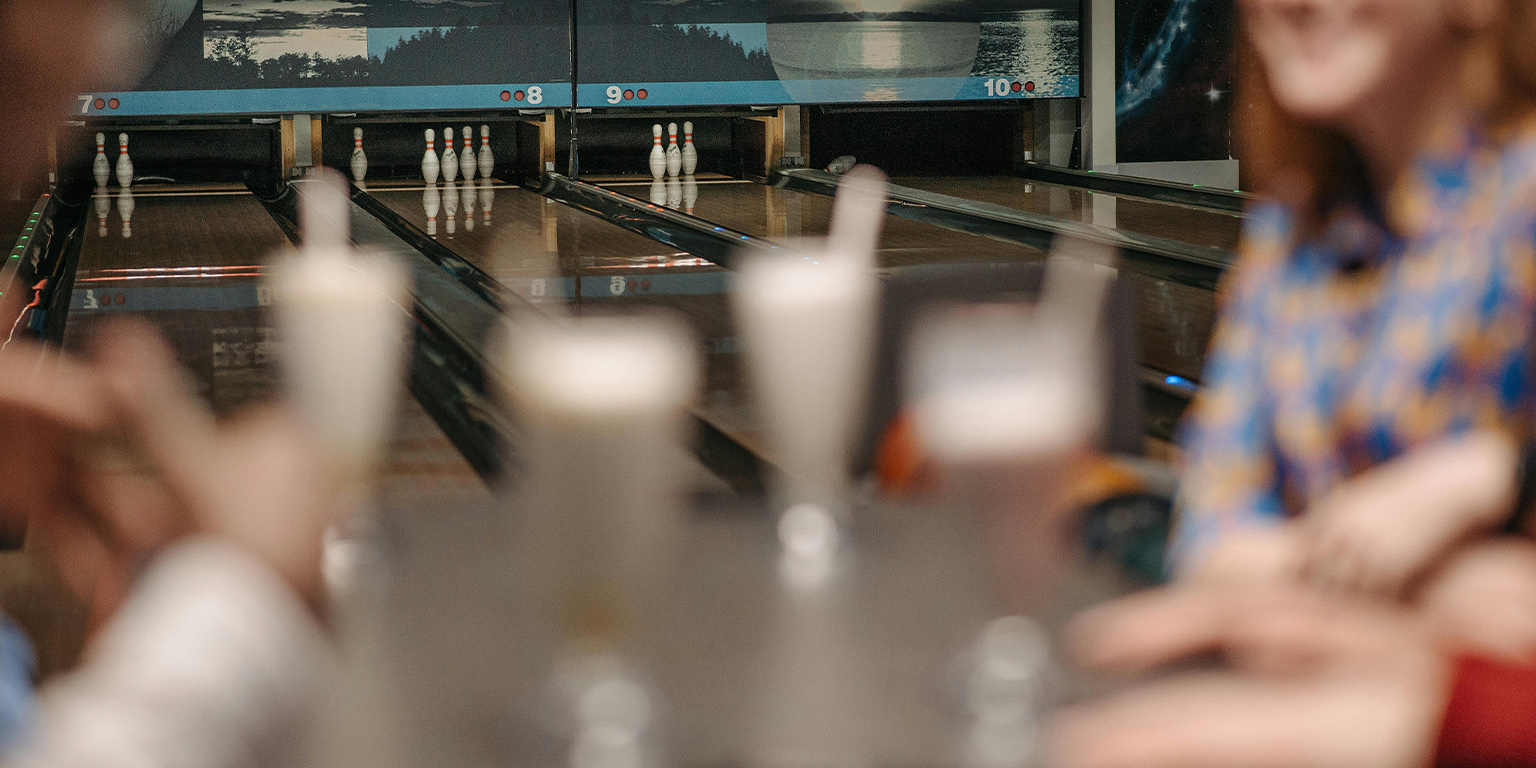 Night Bowling, Friends at a table socializing over Bowling and drinks