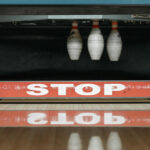 Traditional pinsetters instead of string pinsetters resetting the bowling pins at the end of a bowling lane.