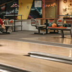 A bowler throwing a bowling ball down the bowling lane